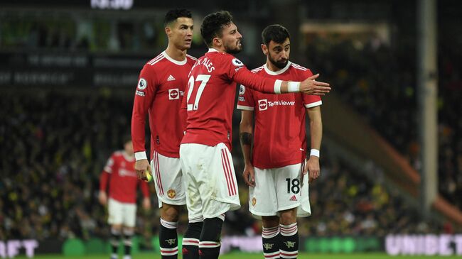 Manchester United's Portuguese striker Cristiano Ronaldo (L), Manchester United's Brazilian defender Alex Telles (C) and Manchester United's Portuguese midfielder Bruno Fernandes (R) prepare to take a freekick during the English Premier League football match between Norwich City and Manchester United at Carrow Road Stadium in Norwich, eastern England, on December 11, 2021. (Photo by Daniel LEAL / AFP) / RESTRICTED TO EDITORIAL USE. No use with unauthorized audio, video, data, fixture lists, club/league logos or 'live' services. Online in-match use limited to 120 images. An additional 40 images may be used in extra time. No video emulation. Social media in-match use limited to 120 images. An additional 40 images may be used in extra time. No use in betting publications, games or single club/league/player publications. / 