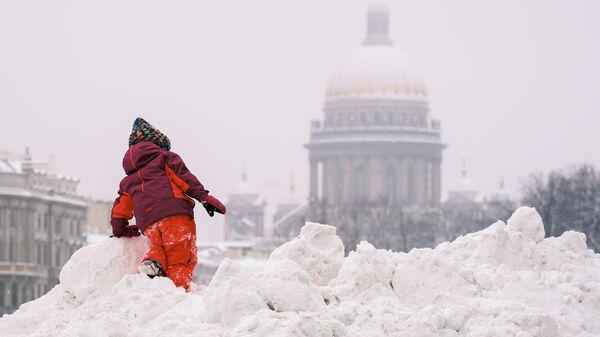 Ребенок играет в снегу на Дворцовой площади в Санкт-Петербурге