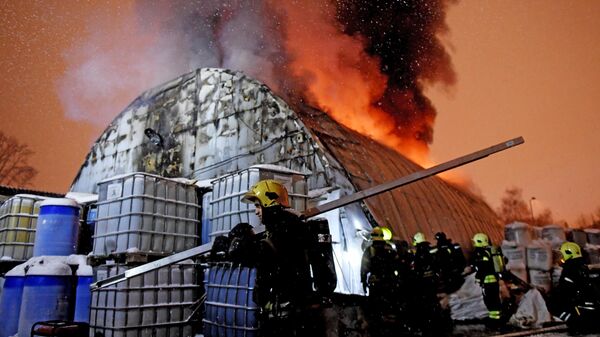 Сотрудники противопожарной службы МЧС России во время тушения пожара в ангаре на Крымском Валу в Москве