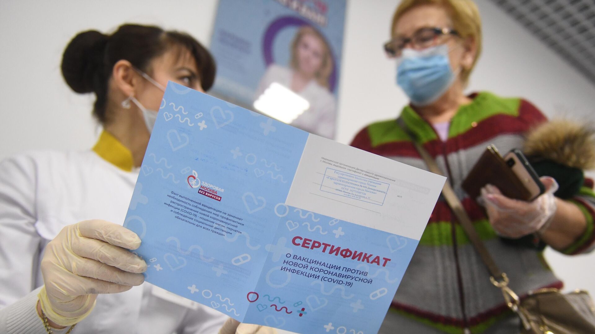 Медицинский работник выдает сертификат о вакцинации от COVID-19 - РИА Новости, 1920, 28.12.2021