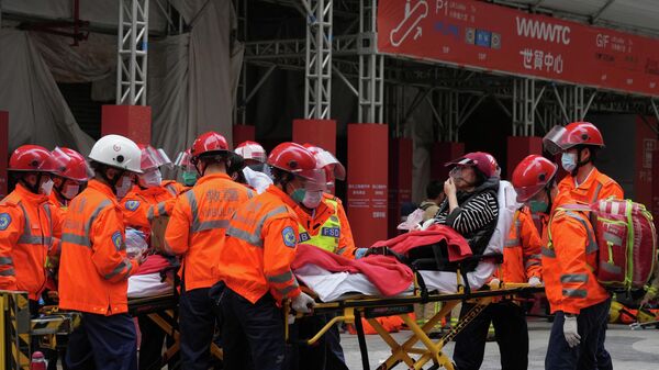 Спасатели эвакуируют пострадавшего в результате пожара во Всемирном торговом центре в Гонконге
