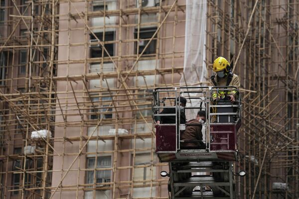 Эвакуация пострадавшего в результате пожара во Всемирном торговом центре в Гонконге