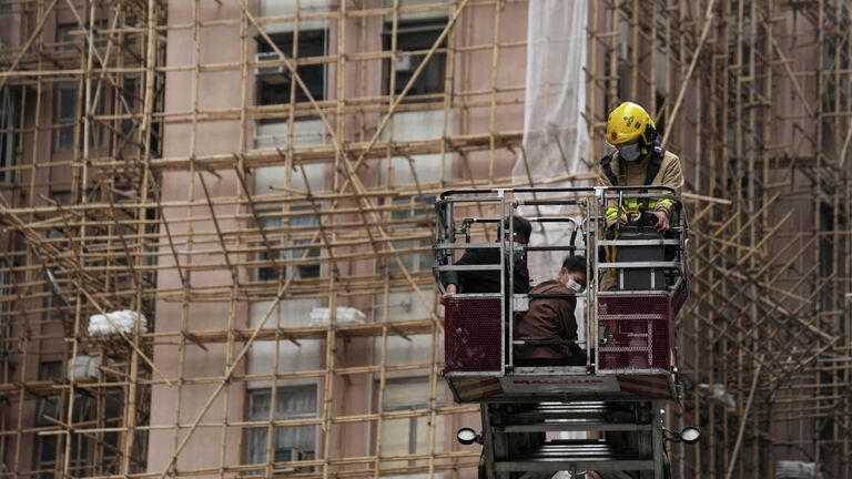 Эвакуация пострадавшего в результате пожара во Всемирном торговом центре в Гонконге