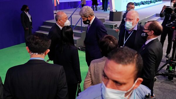 Специальный представитель правительства КНР по климатическим изменениям Се Чжэньхуа  (в центре слева) беседует с Джоном Керри, специальным посланником президента США по вопросам климата (в центре) на саммите ООН по климату COP26 в Глазго