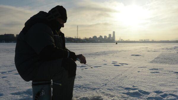Рыбак ловит рыбу на Химкинском водохранилище в Москве