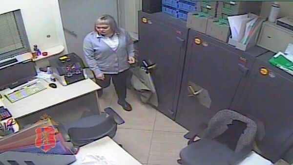 Кадр записи камеры видеонаблюдения с подозреваемой в хищении денег сотрудницей банка в Ачинске