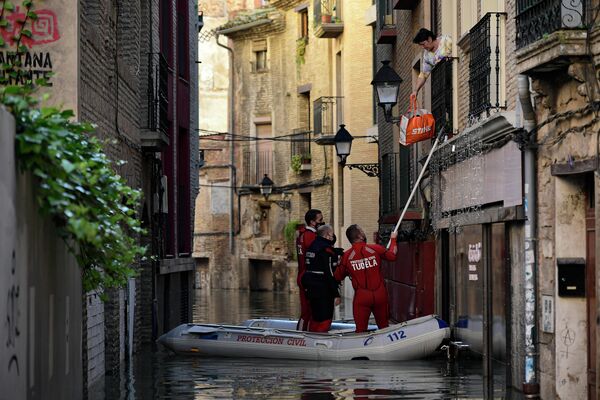 Спасатели эвакуируют женщину из затопленного дома в Туделе, Испания