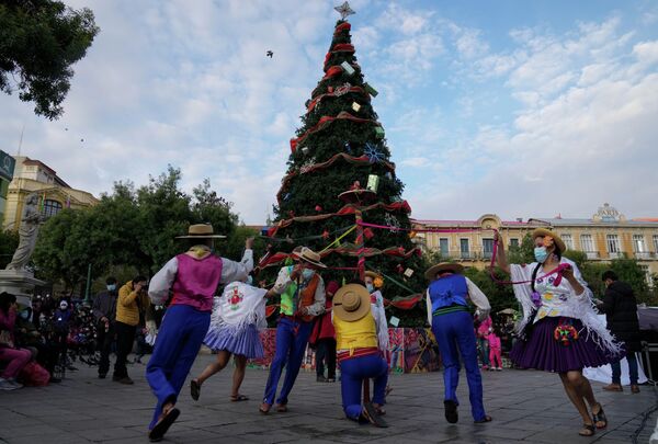 Выступление танцоров на площади Мурильо во время церемонии зажжения рождественской елки в Ла-Пасе, Боливия