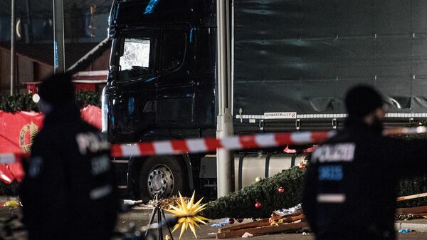 Сотрудники полиции у грузовика, на котором мужчина врезался в посетителей рождественской ярмарки в Берлине