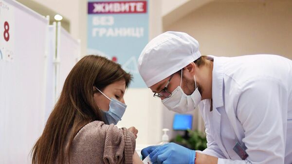 Девушка делает прививку в пункте вакцинации от COVID-19 в ГУМе в Москве