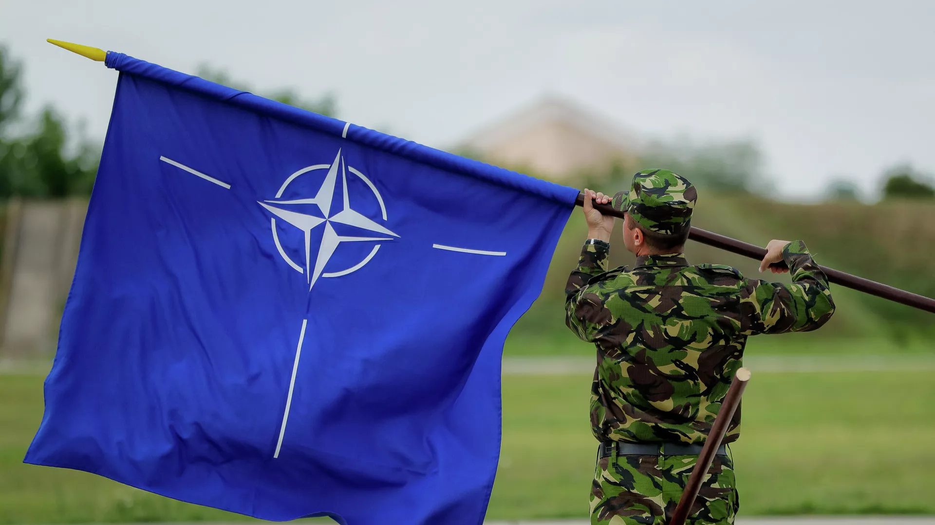 Военнослужащий с флагом НАТО на авиабазе в Румынии. Архивное фото
