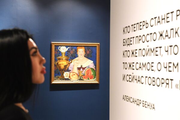 Девушка у картины Бориса Кустодиева Купчиха, пьющая чай (1923 г.), представленной на выставке Азбука шедевра в музее Новый Иерусалим в Московской области
