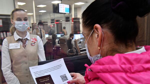 Женщина получает распечатанный бумажный QR-код в многофункциональном центре госуслуг Мои документы в Москве