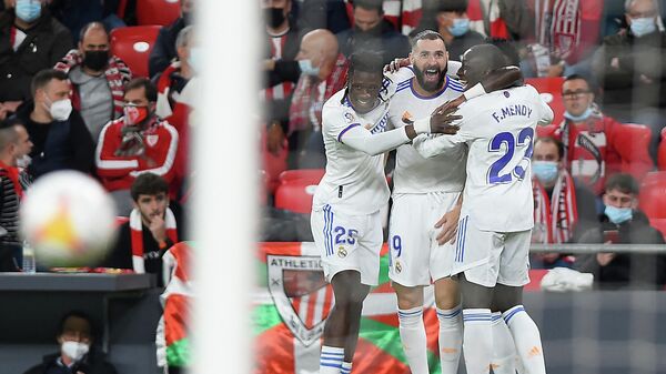 Real Madrid's French forward Karim Benzema (C) celebrates with Real Madrid's French midfielder Eduardo Camavinga (L) and Real Madrid's French defender Ferland Mendy after scoring his team's first goal during the Spanish league football match between Athletic Club Bilbao and Real Madrid CF at the San Mames stadium in Bilbao on December 22, 2021. (Photo by ANDER GILLENEA / AFP)