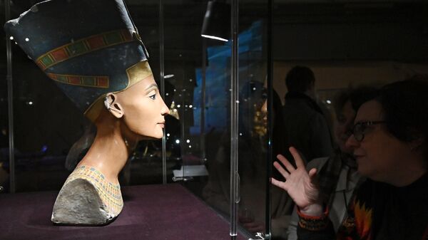 Женщины около экспоната Бюст Нефертити, представленного на выставке Сокровища гробницы Тутанхамона