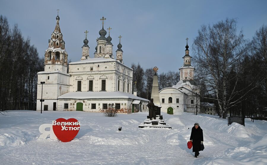 Женщина идет по Комсомольской площади Великого Устюга. На заднем плане Спасо-Преображенский монастырь