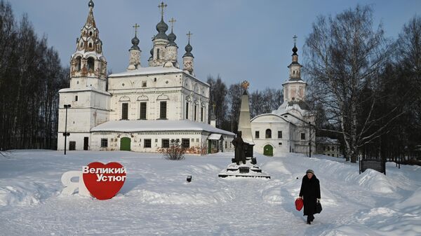 Женщина идет по Комсомольской площади Великого Устюга. На заднем плане Спасо-Преображенский монастырь