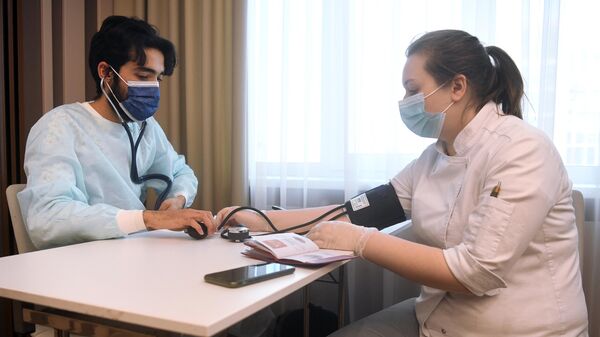 Медицинский сотрудник измеряет давление женщине