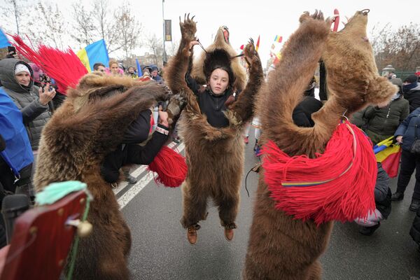 Противники ковид-паспортов в медвежьих шкурах танцуют перед зданием парламента в Бухаресте, Румыния 