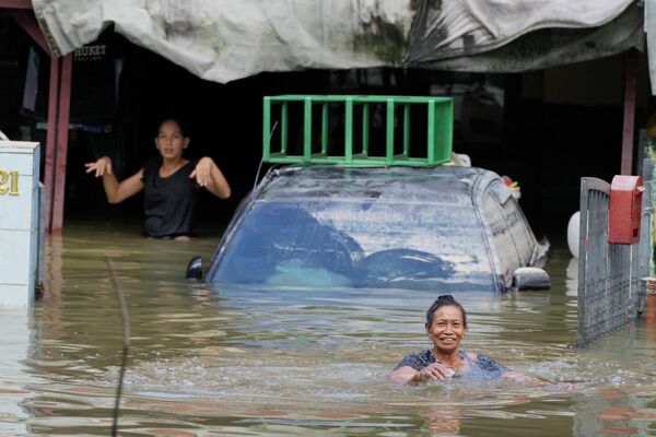 Жители оказались в ловушке в своем доме, пострадавшем от наводнения, в Шах-Аламе, на окраине Куала-Лумпура, Малайзия.