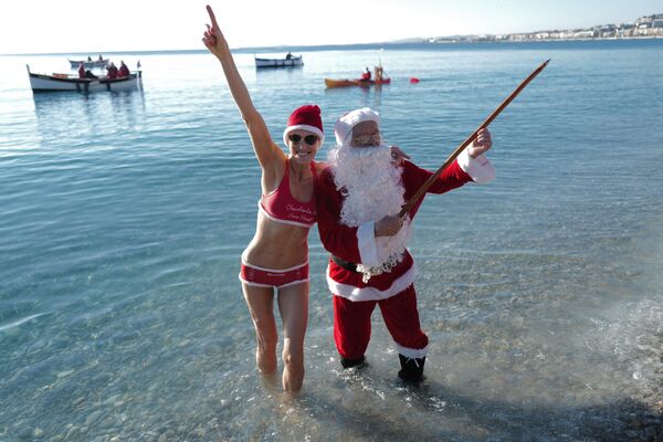 Мужчина в костюме Санта-Клауса c девушкой в Ницце на Французской Ривьере