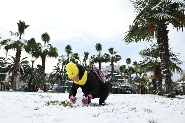 Девочка лепит снеговика в центре Сочи