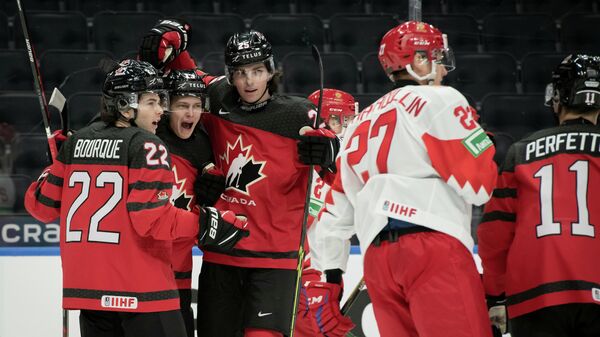 Хоккеисты молодежной сборной Канады празднуют гол в матче с командой России