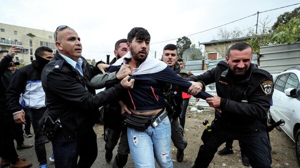 Сотрудники службы безопасности Израиля задерживают палестинца во время столкновений в Восточном Иерусалиме 