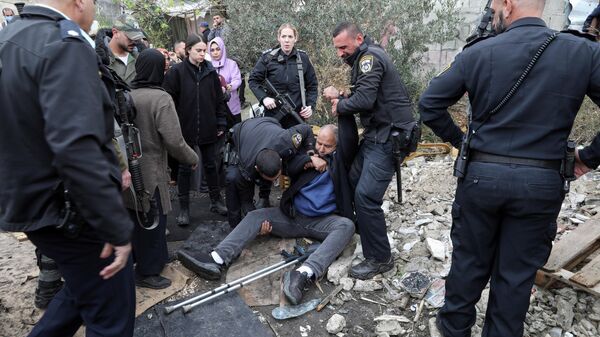 Израильские полицейские задерживают палестинца во время столкновений в Восточном Иерусалиме