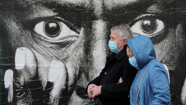Люди в защитных масках на улице Крещатик в Киеве