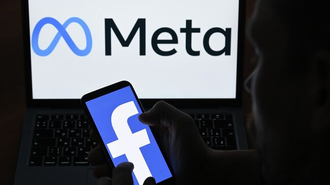 Логотипы компании Facebook и Meta на экранах смартфона и монитора