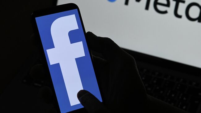 Логотипы компании Facebook и Meta на экранах смартфона и монитора