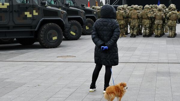 Женщина смотрит на группу военнослужащих во время репетиции парада ко Дню Вооруженных сил Украины
