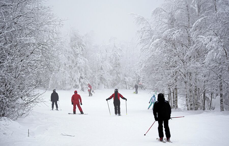 Сноубордисты  и лыжники на северном склоне горы Крестовой горнолыжного курорта Губаха в Пермском крае