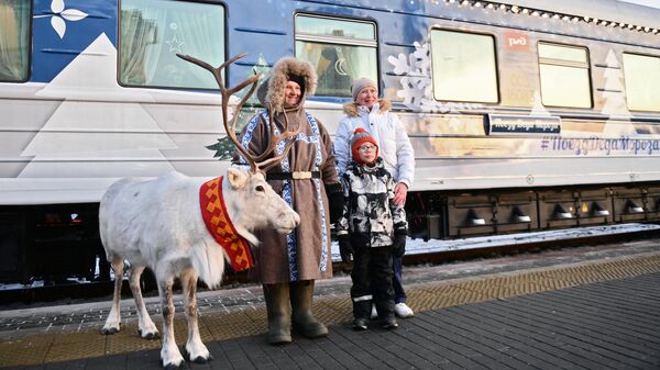 Люди фотографируются с северным оленем у Сказочного поезда Деда Мороза, прибывшего из Великого Устюга, на вокзале Екатеринбурга