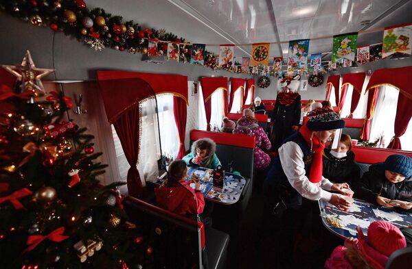 Дети получают угощение в вагоне-ресторане Сказочного поезда Деда Мороза, прибывшего из Великого Устюга на вокзал Екатеринбурга