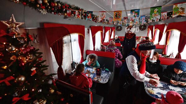 Дети получают угощение в вагоне-ресторане Сказочного поезда Деда Мороза, прибывшего из Великого Устюга на вокзал Екатеринбурга