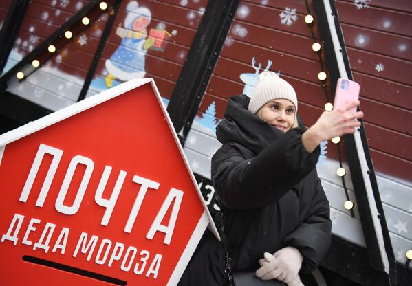 Девушка фотографируется на фоне сказочного поезда Деда Мороза, прибывшего на железнодорожный вокзал в Казань