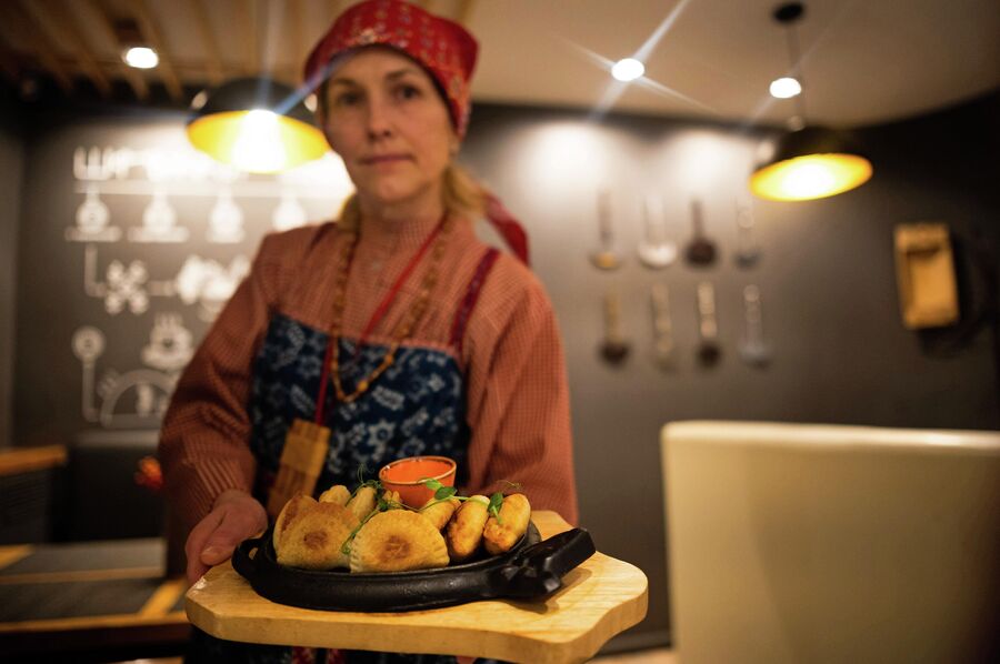 Экскурсовод демонстрирует Посикунчики в кафе-музее Пермская кухня в Перми