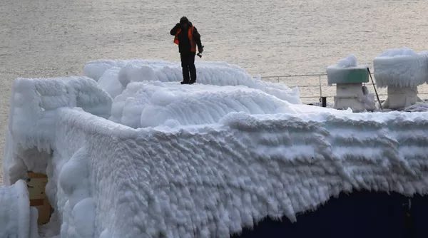 Мужчина на борту сухогруза Sun Rio, который прибыл в порт Владивостока с автомобилями, покрытыми толстым слоем льда
