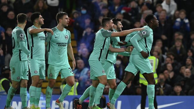 Brighton's English striker Danny Welbeck (R) celebrates with teammates after he scores his team's opening goal during the English Premier League football match between Chelsea and Brighton and Hove Albion at Stamford Bridge in London on December 29, 2021. (Photo by Glyn KIRK / AFP) / RESTRICTED TO EDITORIAL USE. No use with unauthorized audio, video, data, fixture lists, club/league logos or 'live' services. Online in-match use limited to 120 images. An additional 40 images may be used in extra time. No video emulation. Social media in-match use limited to 120 images. An additional 40 images may be used in extra time. No use in betting publications, games or single club/league/player publications. / 