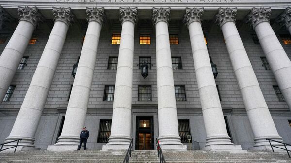 Пристав стоит перед зданием суда Соединенных Штатов, пока присяжные обсуждают дело Гилейн Максвелл