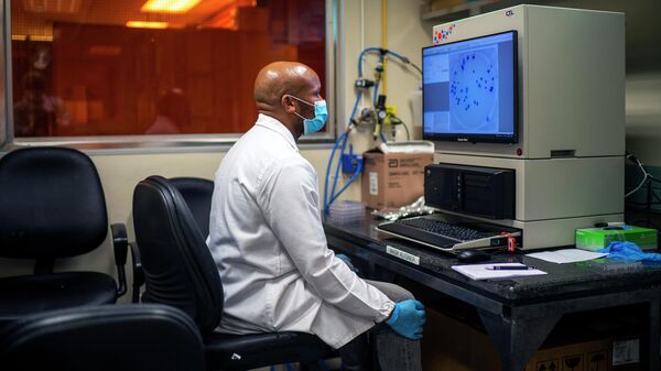 Сотрудник Африканского научно-исследовательского института здравоохранения работает с омикрон-штаммом вируса COVID-19 в Дурбане, ЮАР