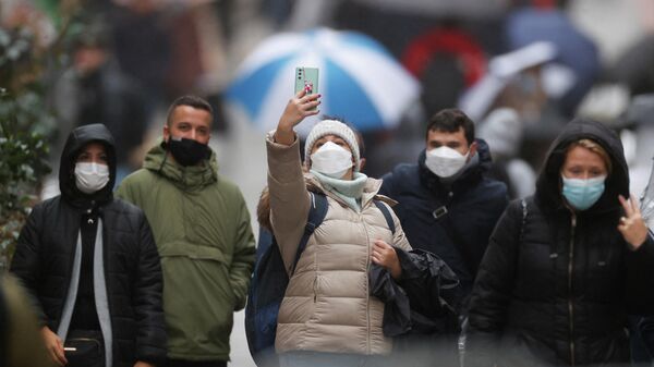 Люди в защитных масках на улице в Париже, Франция