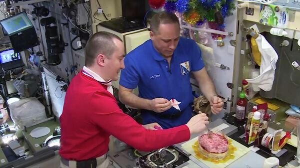 Космонавты Петр Дубров и Антон Шкаплеров готовят селедку под шубой на МКС. Кадр видео