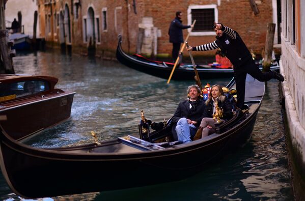Гондолы с туристами на канале в Венеции