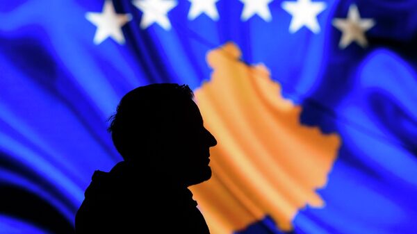Мужчина на фоне флага Косово в Приштине