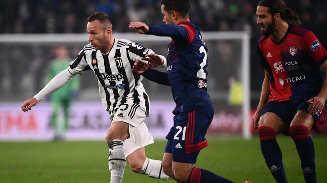 Juventus' Brazilian midfielder Arthur (L) outruns Cagliari's Uruguayan midfielder Christian Oliva during the Italian Serie A football match between Juventus and Cagliari on December 21, 2021 at the Juventus stadium in Turin. (Photo by Marco BERTORELLO / AFP)