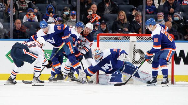 ELMONT, NEW YORK - JANUARY 01: Ilya Sorokin #30 of the New York Islanders defends the net against Jesse Puljujarvi #13 and Connor McDavid #97 of the Edmonton Oilers during the second period at the UBS Arena on January 01, 2022 in Elmont, New York.   Bruce Bennett/Getty Images/AFP (Photo by BRUCE BENNETT / GETTY IMAGES NORTH AMERICA / Getty Images via AFP)