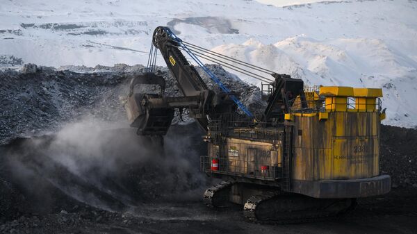 Экскаватор во время добычи угля на Виноградовском разрезе в Беловском районе Кемеровской области